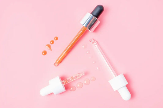 Pipete cu ser si picaturi pe fundal roz