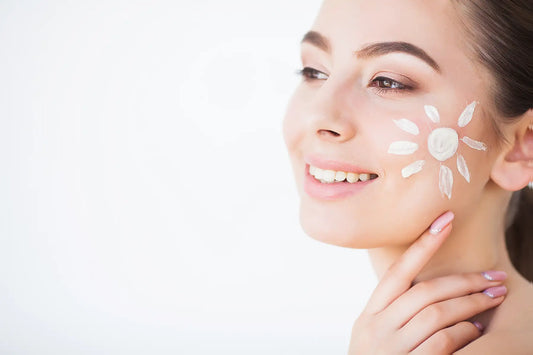 Femeie zambitoare cu crema de protectie solara aplicata in forma de floare pe obraz