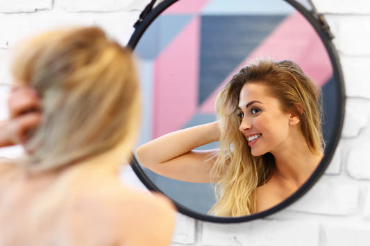 Woman with glowing skin posing in bathroom after skincare routine